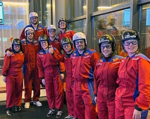 緑の旗で装飾されたテーマイベントで、同僚たちが笑顔で一緒にポーズをとっている。