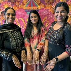 お祝いの旗で飾られたオフィススペースで、楽しそうにポーズをとっている同僚たち。