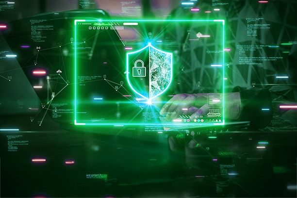 An individual working on a laptop with a shield and a lock superimposed on it with a neon green square bordering the shield
